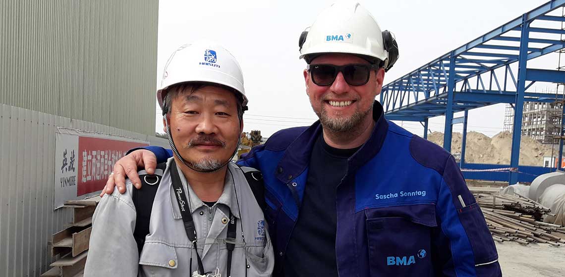 [Translate to Russisch:] BMA-Mitarbeiter auf einer Baustellen mit einem Kunden